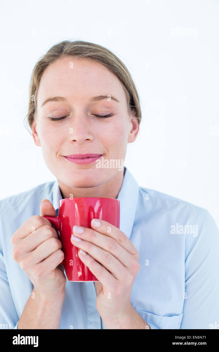 Businesswoman smelling her coffee Stock Photo