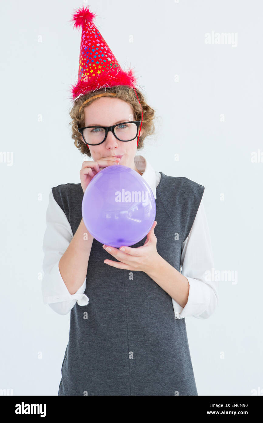Geeky hipster blowing up balloon Stock Photo