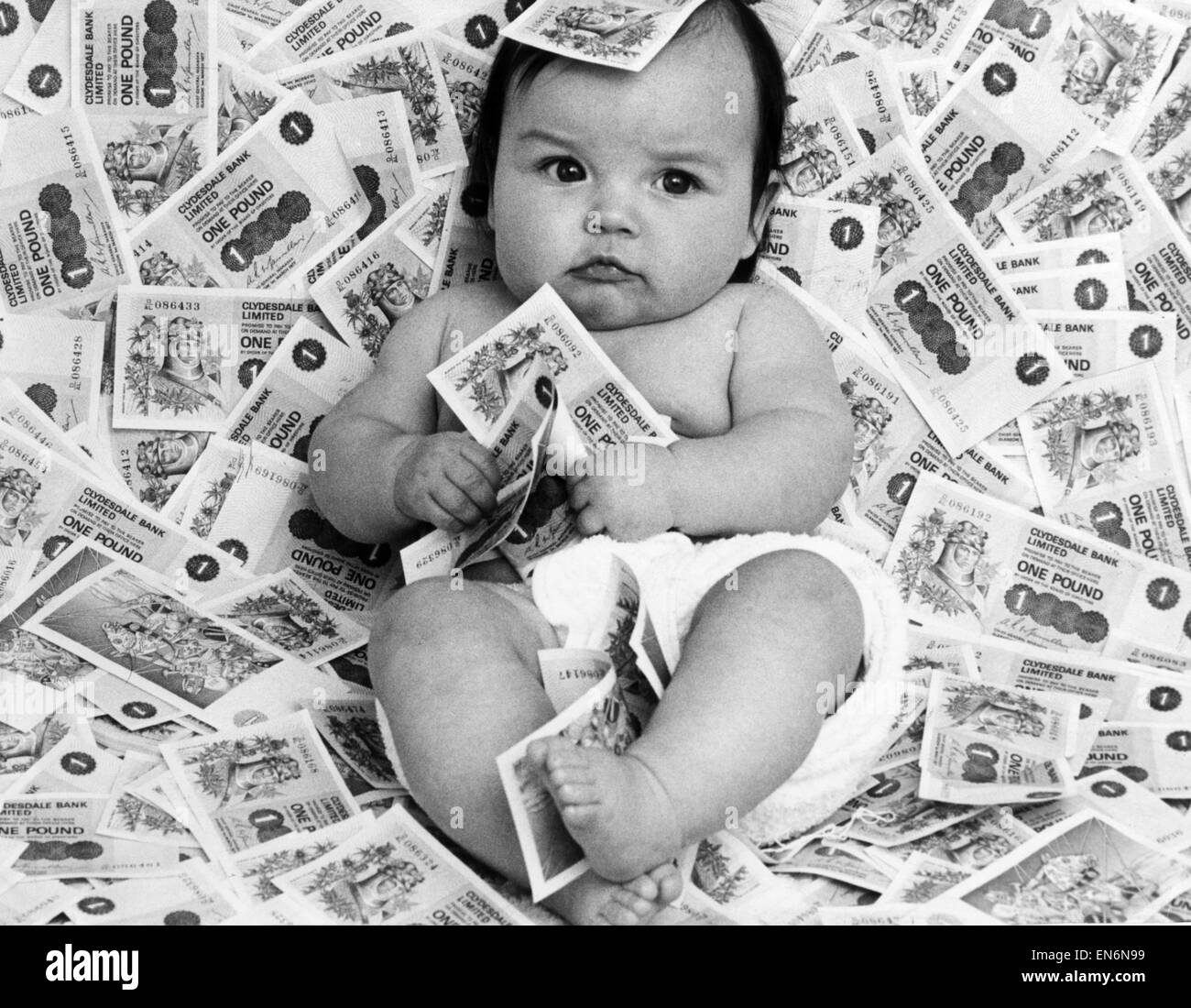 Baby Diane from Glasgow, Scotland, surrounded by bank notes from Clydesdale Bank Limited, September 1977. Stock Photo