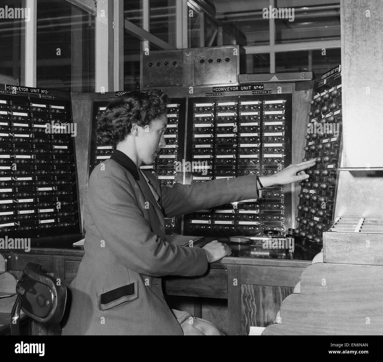 Picture to accompany the 'Robot Revolution' feature which ran in the Daily Mirror newspaper on the week commencing 27th June 1955. Picture shows: A worker sits at one of the panels in the Central Conveyor Control room at the Motor Winding plant of Brook M Stock Photo