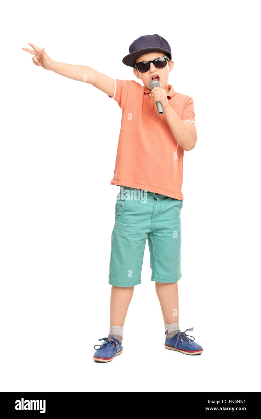 Full length portrait of a little boy in hip hop outfit rapping on a microphone and gesturing with his hand Stock Photo
