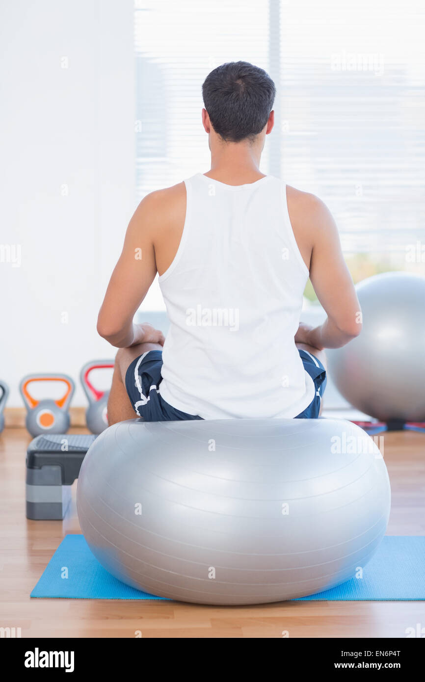 Man sitting on exercise ball Stock Photo