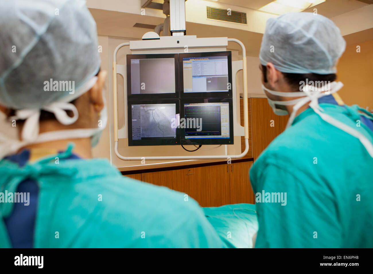 Surgeons looking at screen Stock Photo