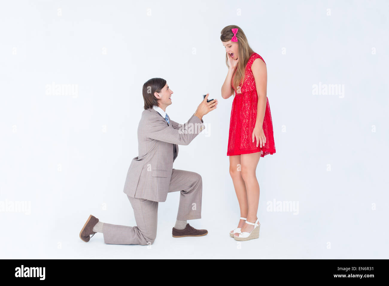 Hipster on bended knee doing a marriage proposal to his girlfriend Stock Photo