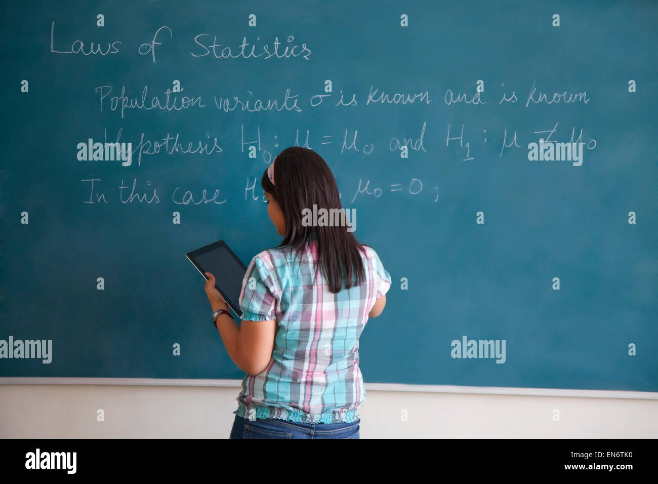 College student writing on blackboard Stock Photo
