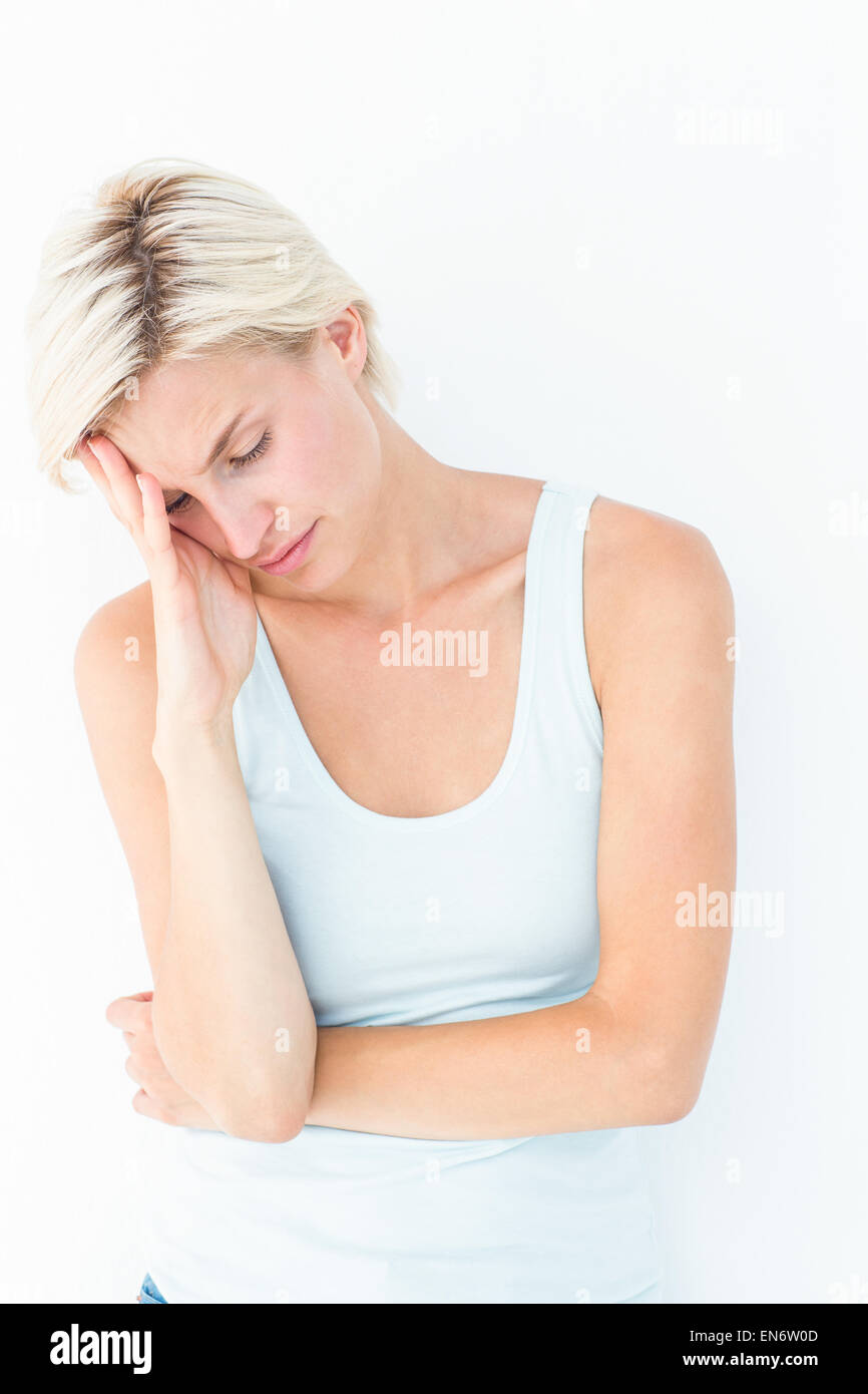 Depressed blonde woman with hand on temple Stock Photo