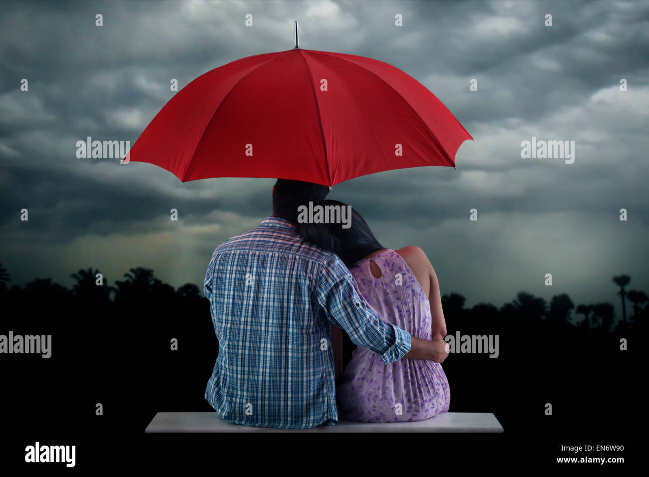 Couple with umbrella sitting hi-res stock photography and images - Alamy