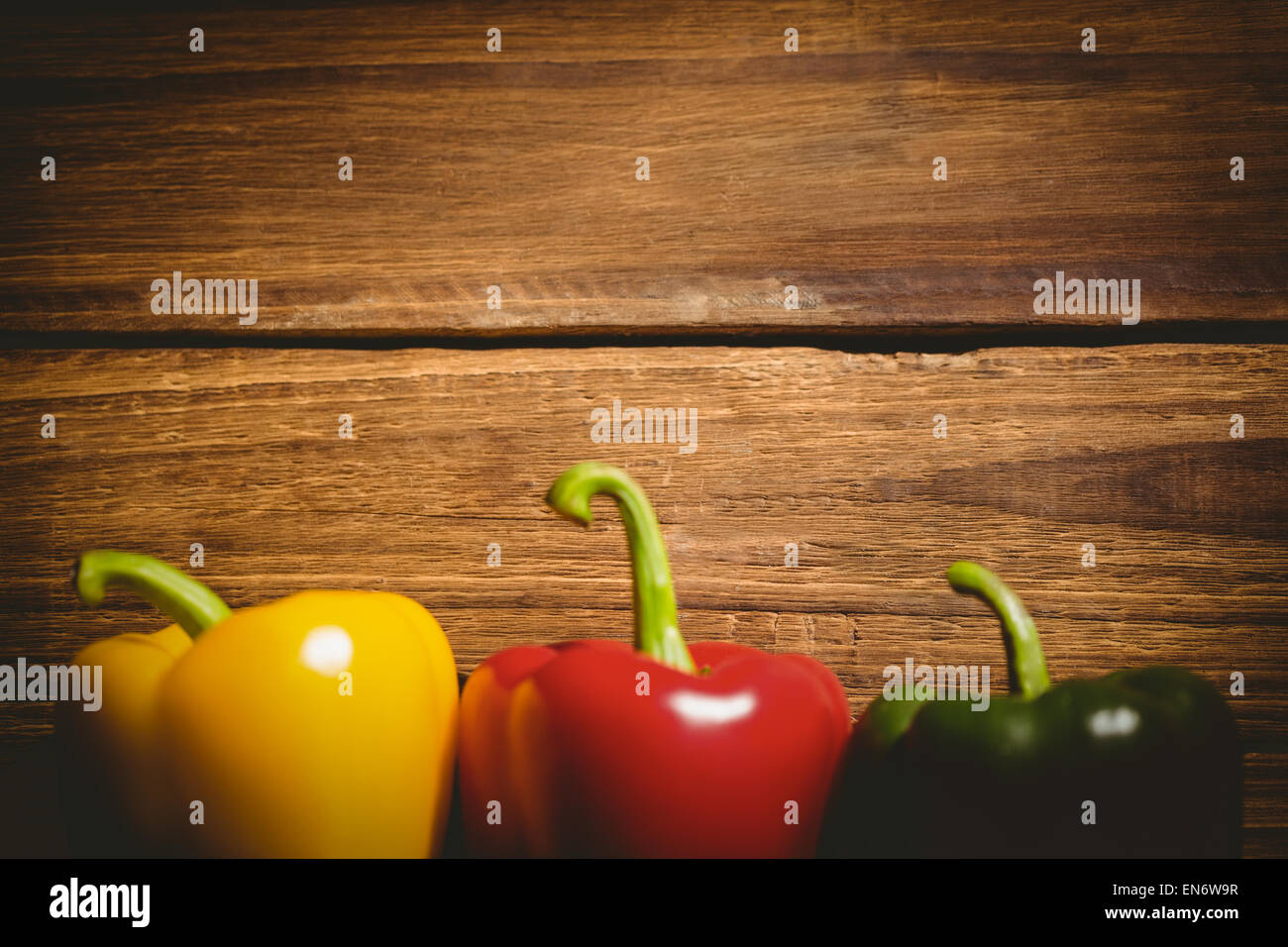 Three peppers on chopping board Stock Photo - Alamy