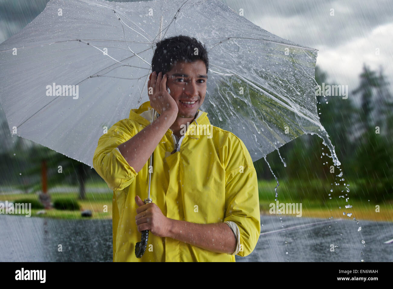 Man with umbrella talking on mobile phone Stock Photo