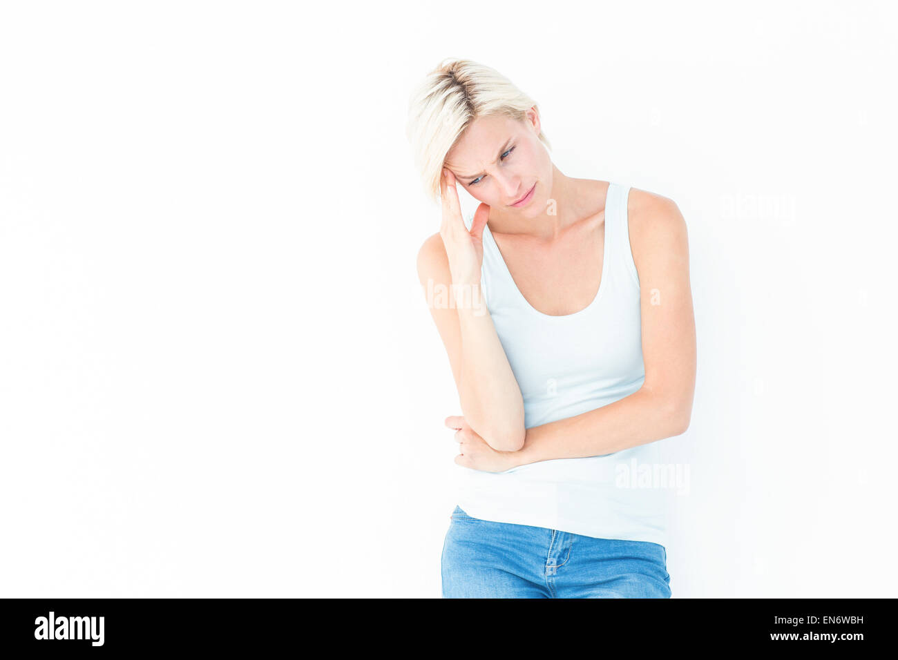Depressed blonde woman with hand on temple Stock Photo