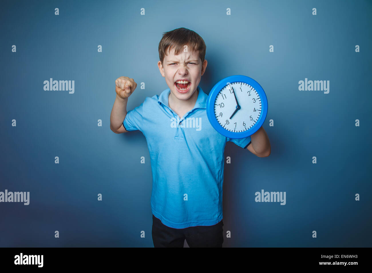 teenager boy brown European appearance holds a clock showing thumb up ...