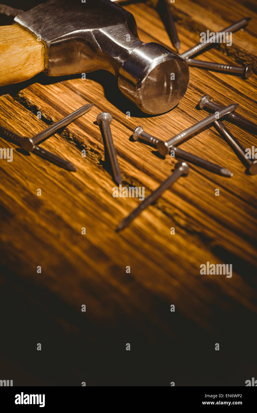 Hammer and nails laid out on table Stock Photo