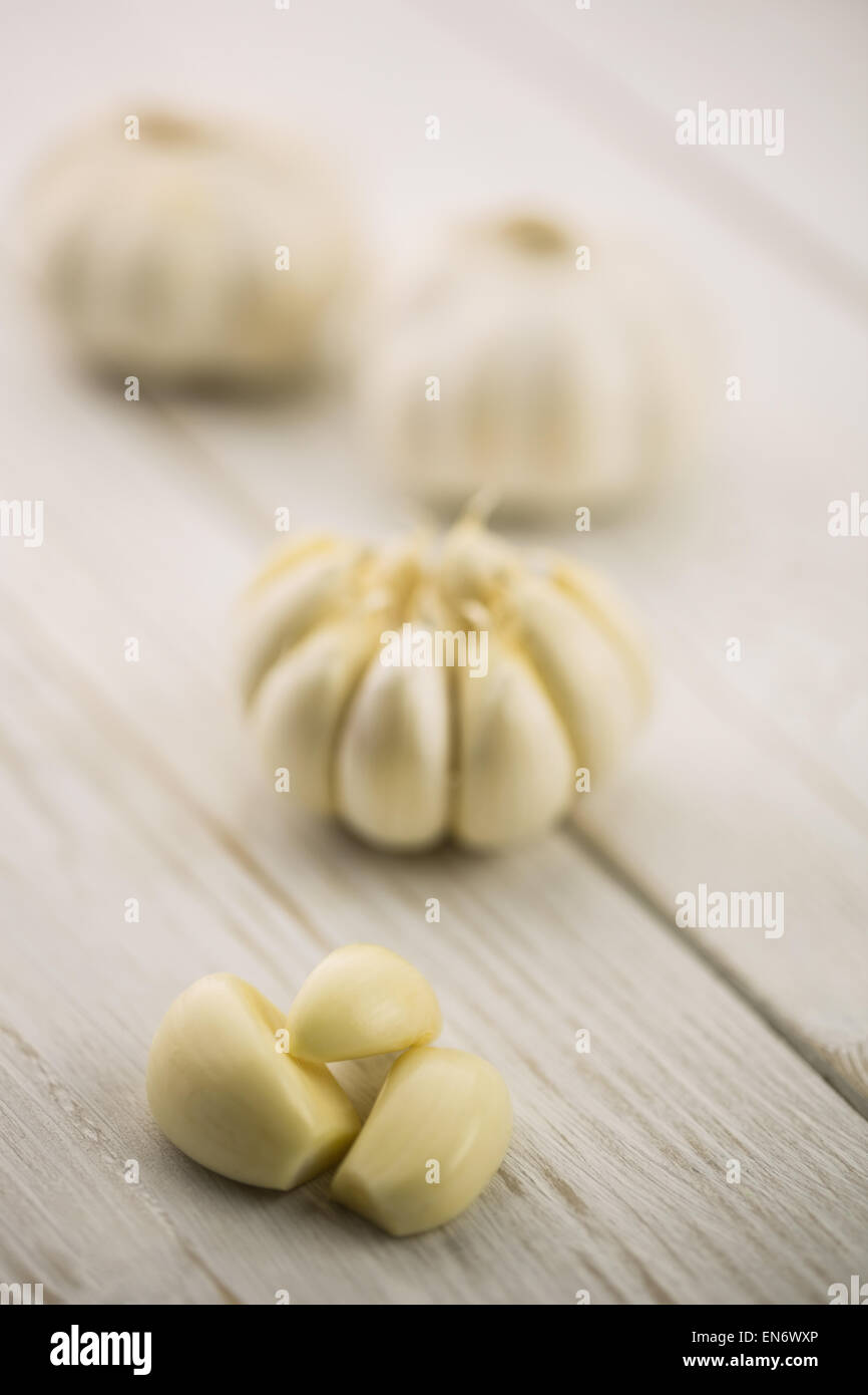 Garlic cloves and bulb on chopping board Stock Photo - Alamy