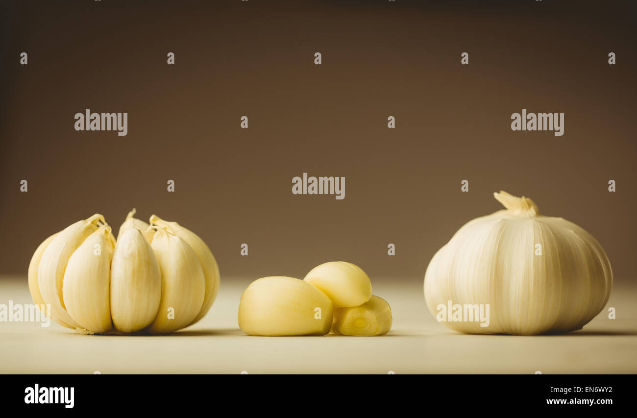 Garlic cloves and bulb on chopping board Stock Photo - Alamy