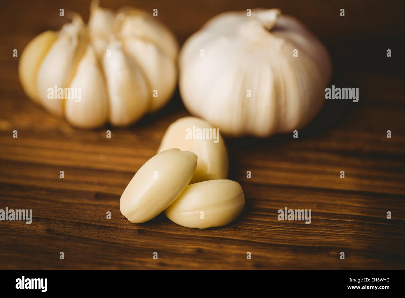 Garlic cloves and bulb on chopping board Stock Photo - Alamy