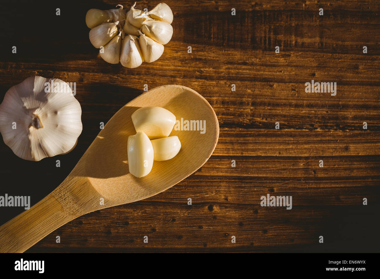 Garlic cloves and bulb on chopping board Stock Photo - Alamy
