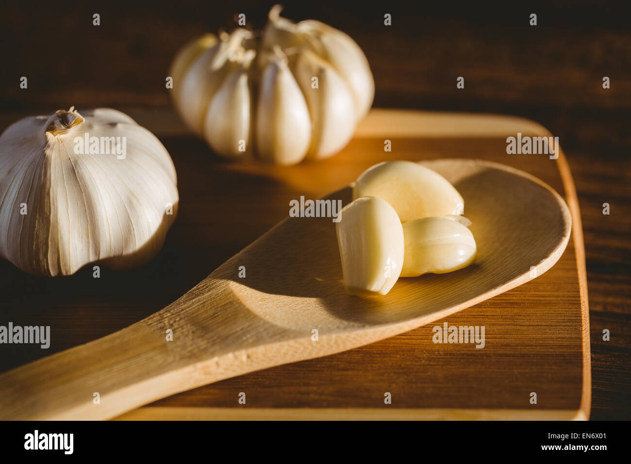 Garlic cloves and bulb on chopping board Stock Photo - Alamy
