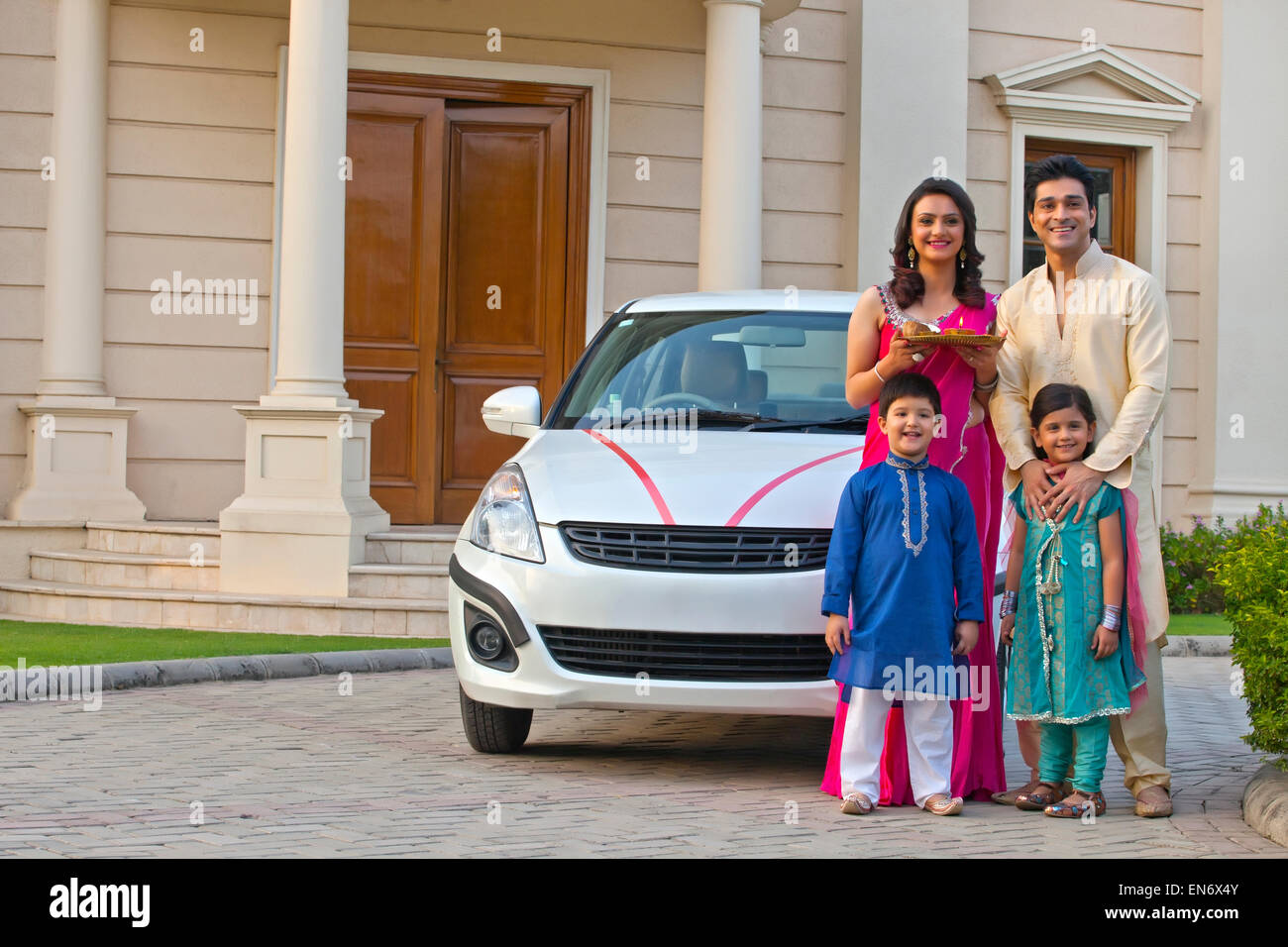 Family standing next to new car Stock Photo