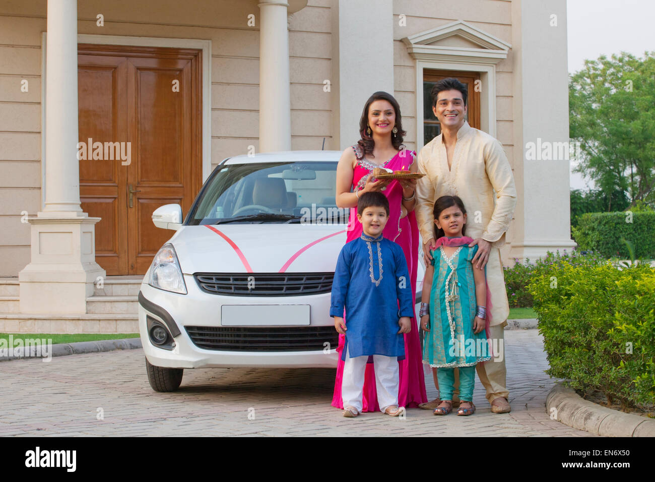 Family standing next to new car Stock Photo