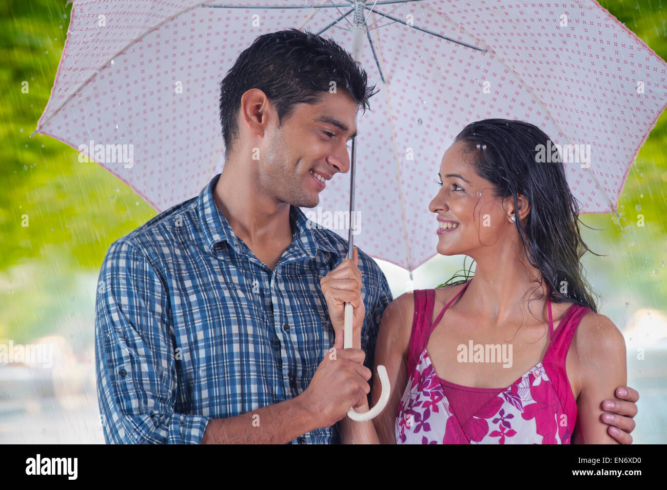 Couple with umbrella enjoying the rain Stock Photo - Alamy