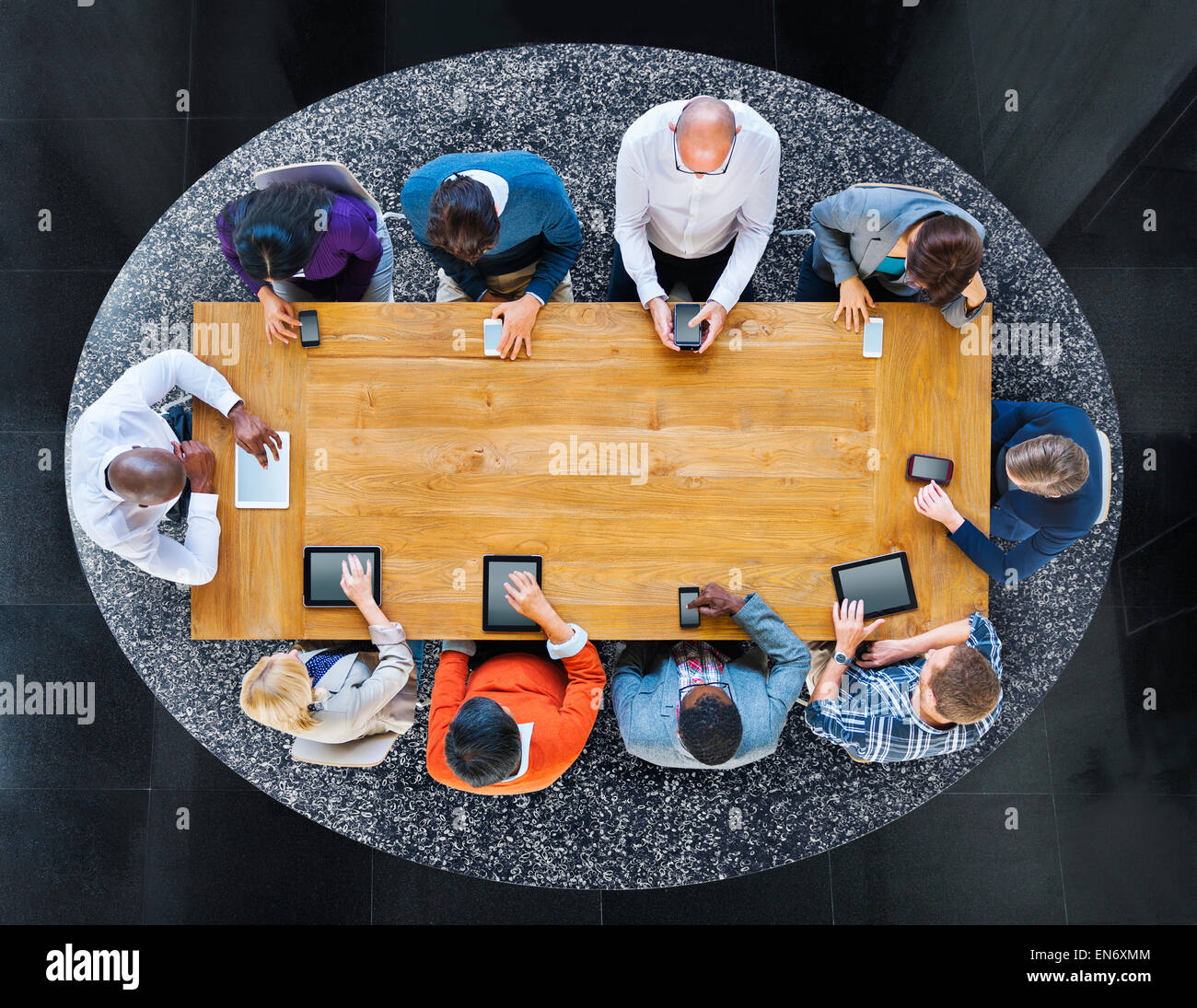 Group of Diverse People in a Table Using Devices Stock Photo - Alamy