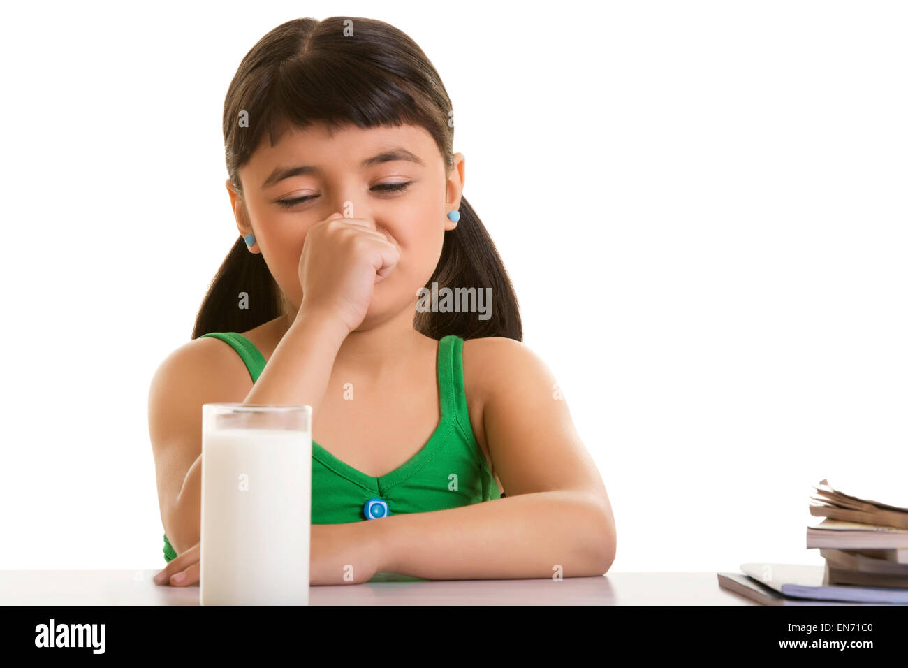 Girl fussing over a glass of milk Stock Photo