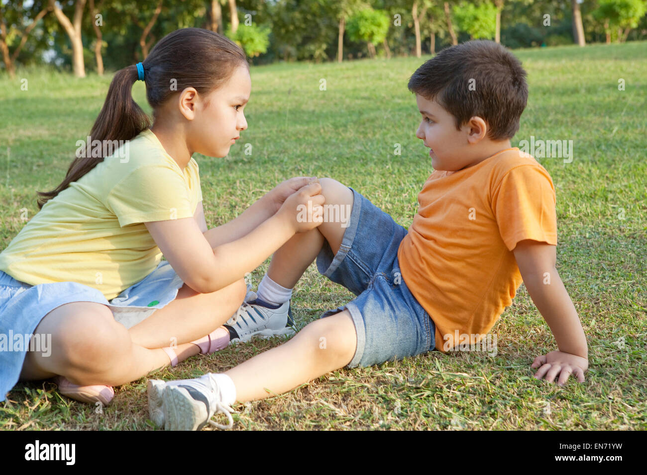 Girl putting bandaid on brothers leg Stock Photo Alamy