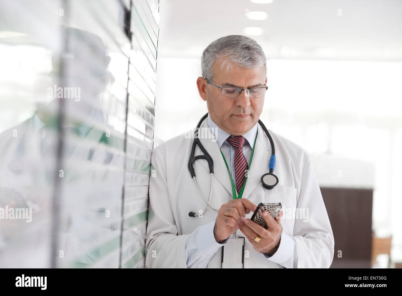 Doctor reading sms on mobile phone Stock Photo