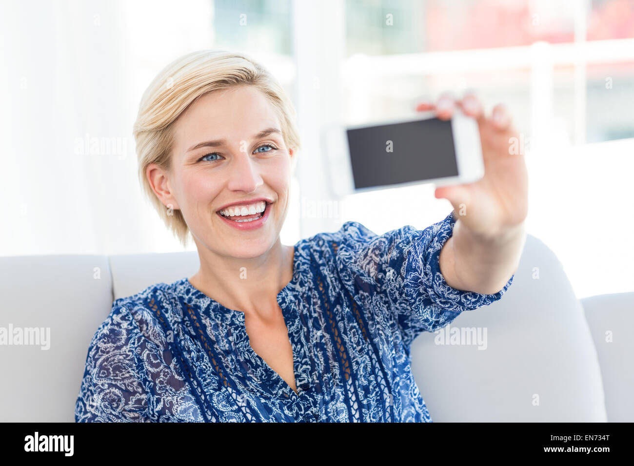 Pretty blonde woman taking a selfie Stock Photo - Alamy