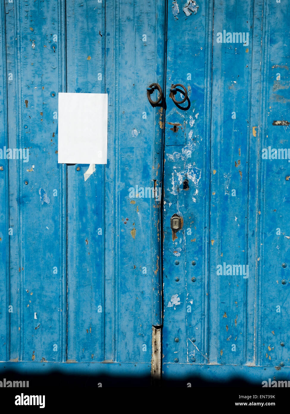 Antique blue wooden door with a paper in blank. Stock Photo