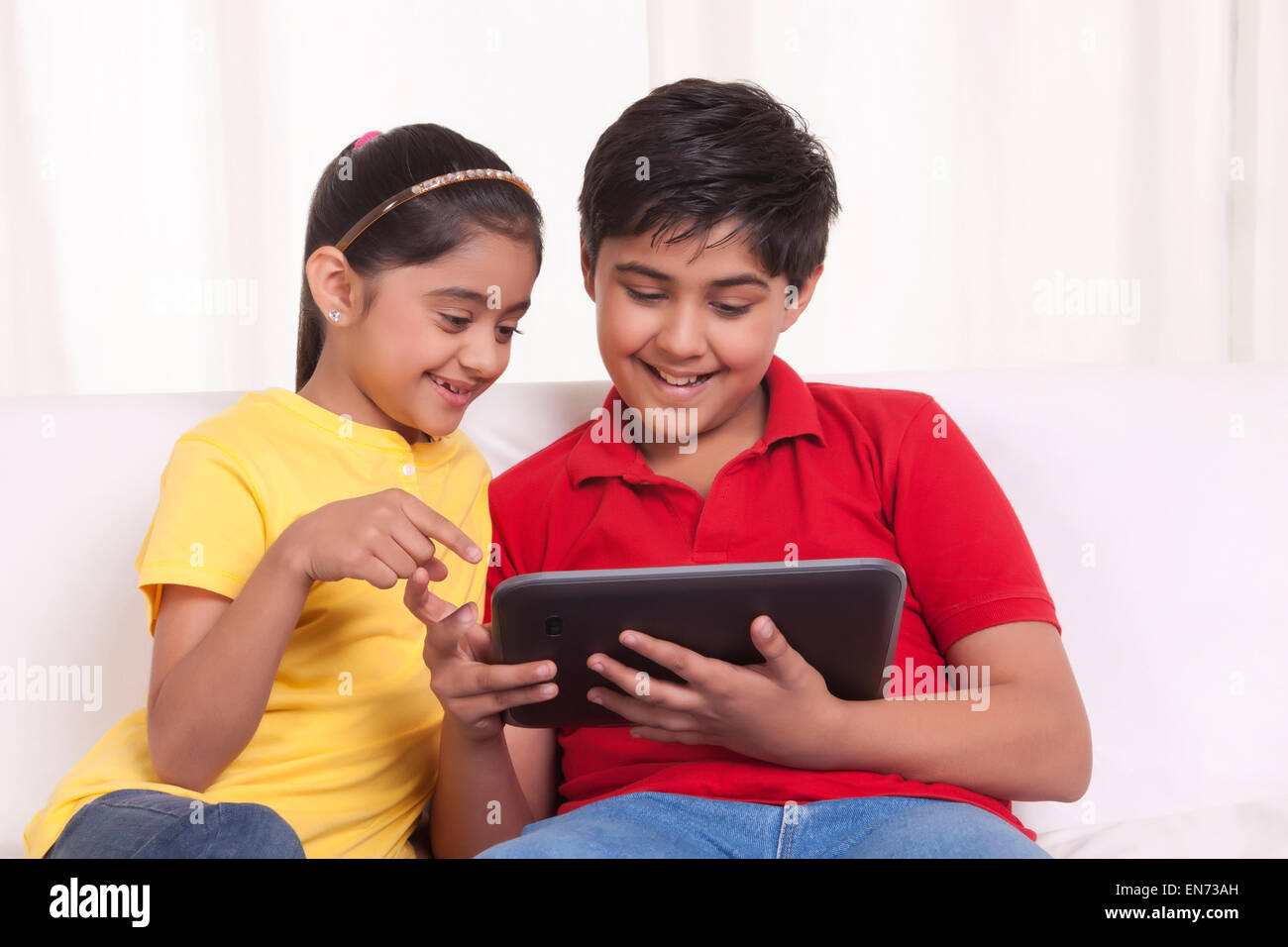 Brother and sister using digital tablet Stock Photo - Alamy