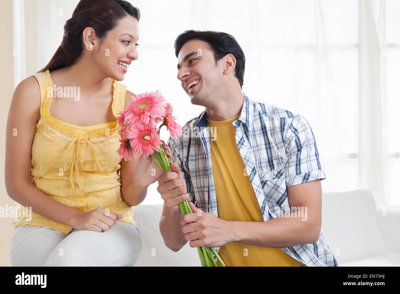 Indian man giving flowers to woman hires stock photography and images