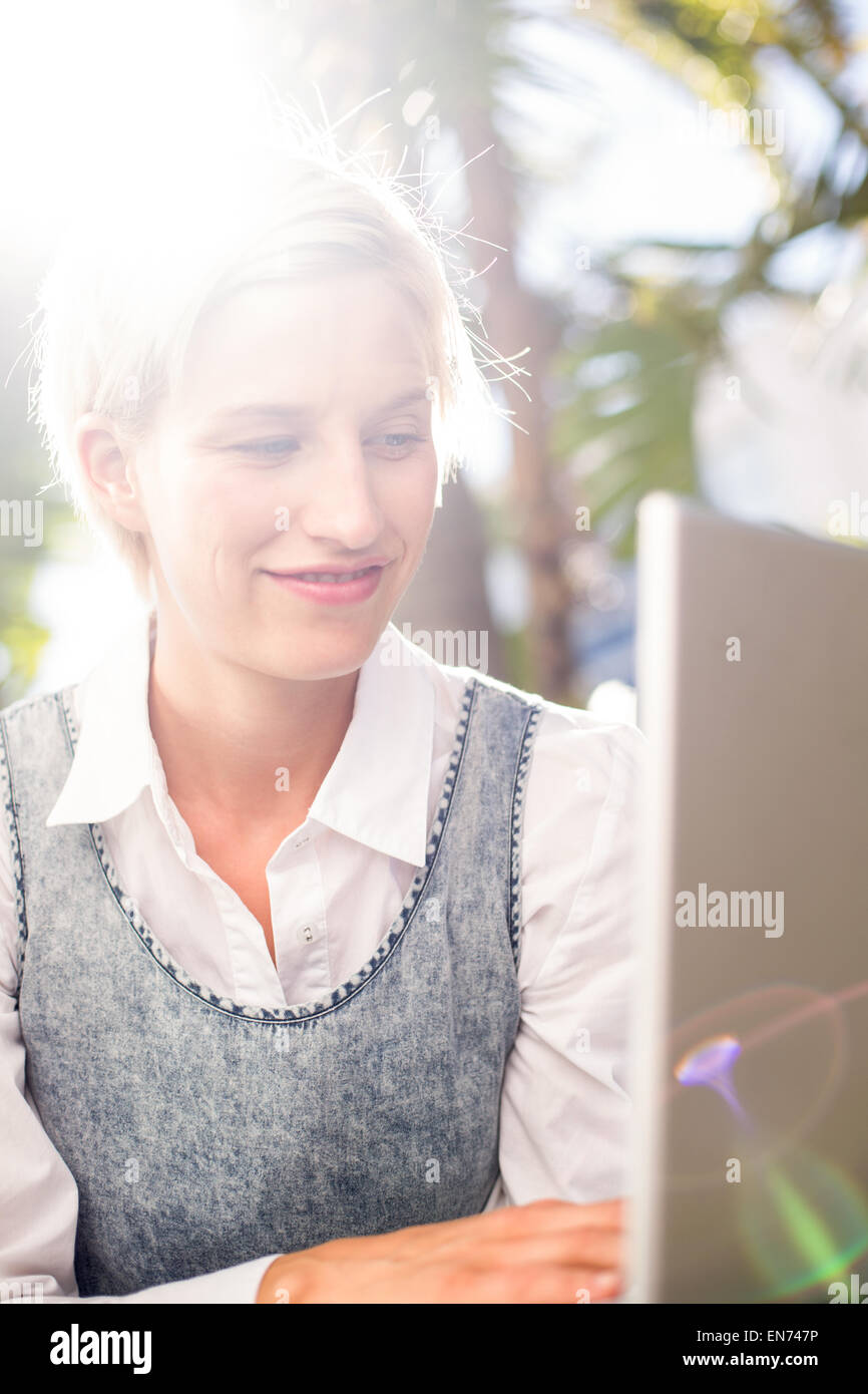 Pretty blonde woman using her laptop Stock Photo - Alamy