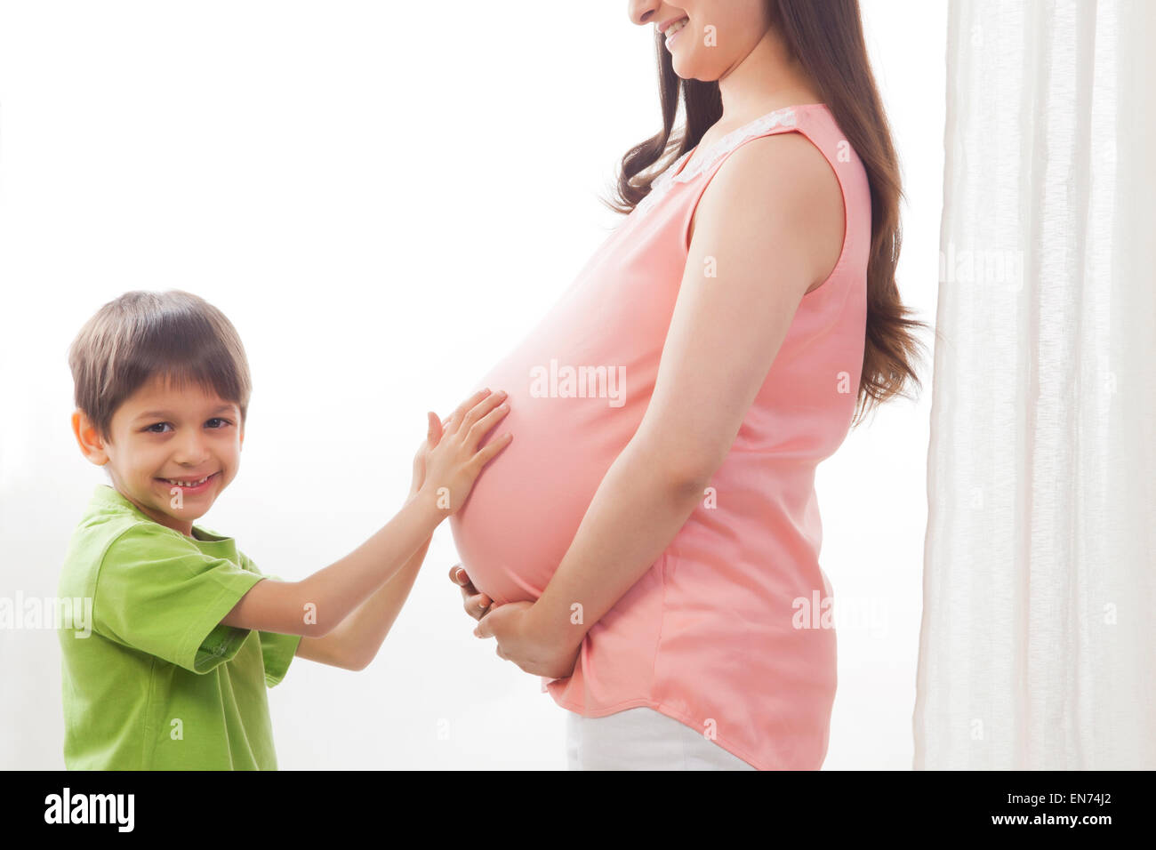 Portrait of boy touching mother pregnant belly Stock Photo Alamy