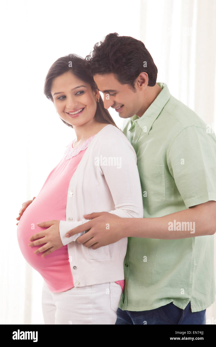 Man embracing pregnant woman Stock Photo - Alamy