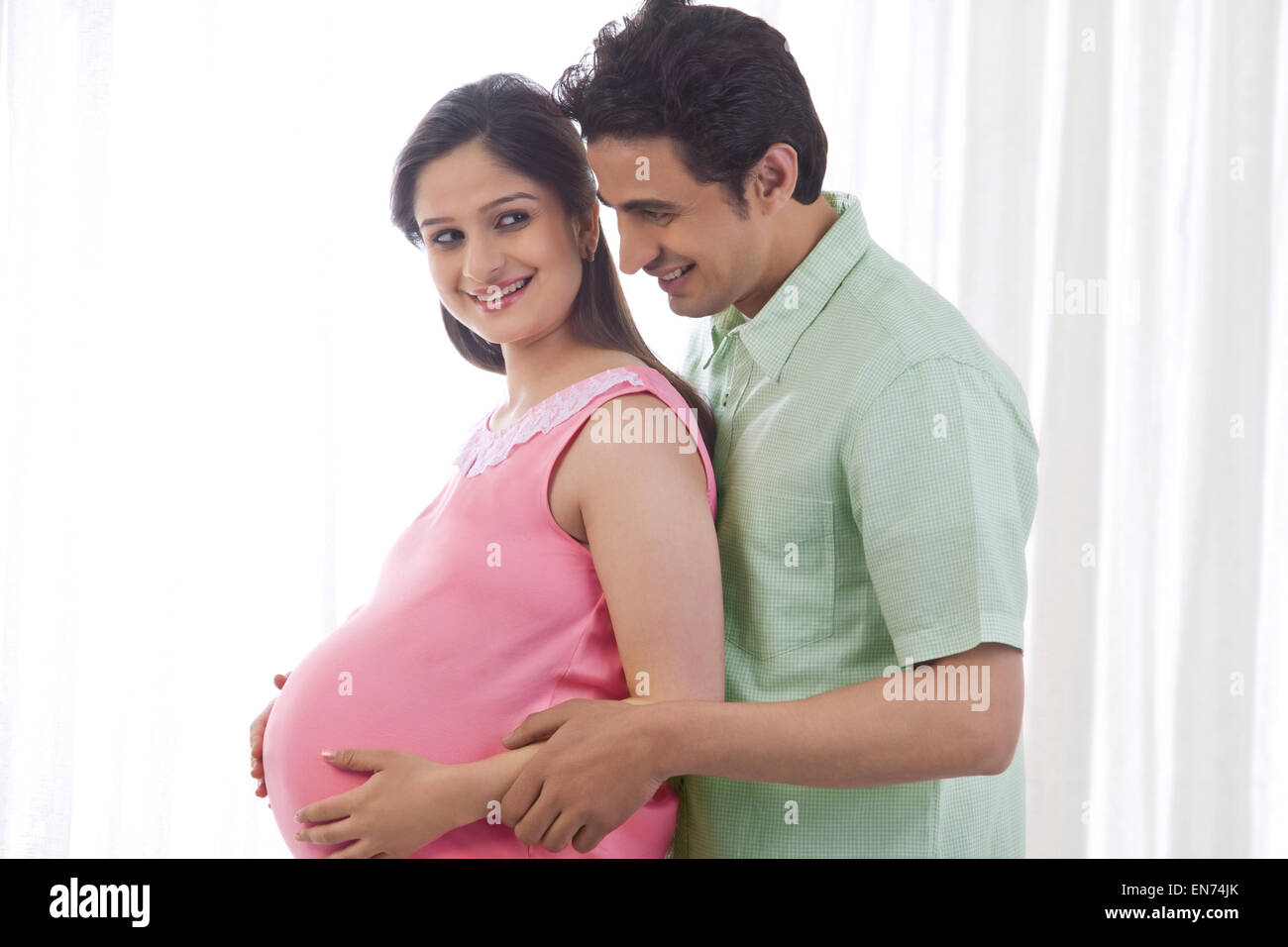 Man embracing pregnant woman Stock Photo - Alamy