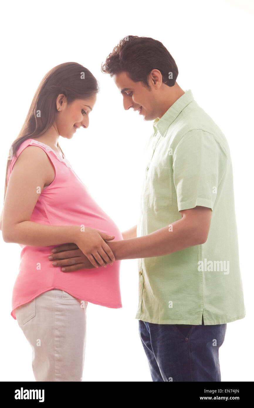 Man with hands on pregnant womans stomach Stock Photo