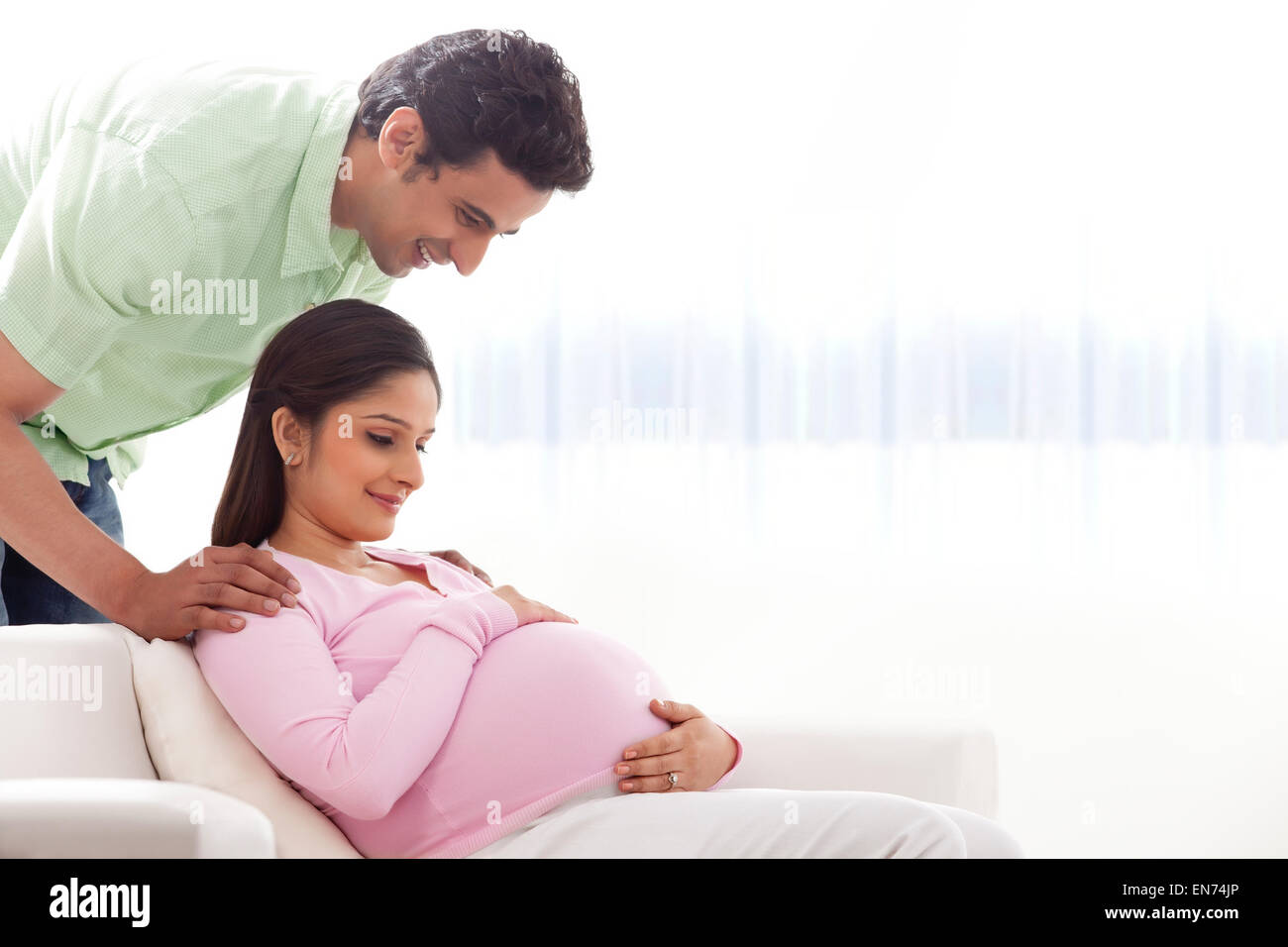 Man looking at pregnant womans belly Stock Photo