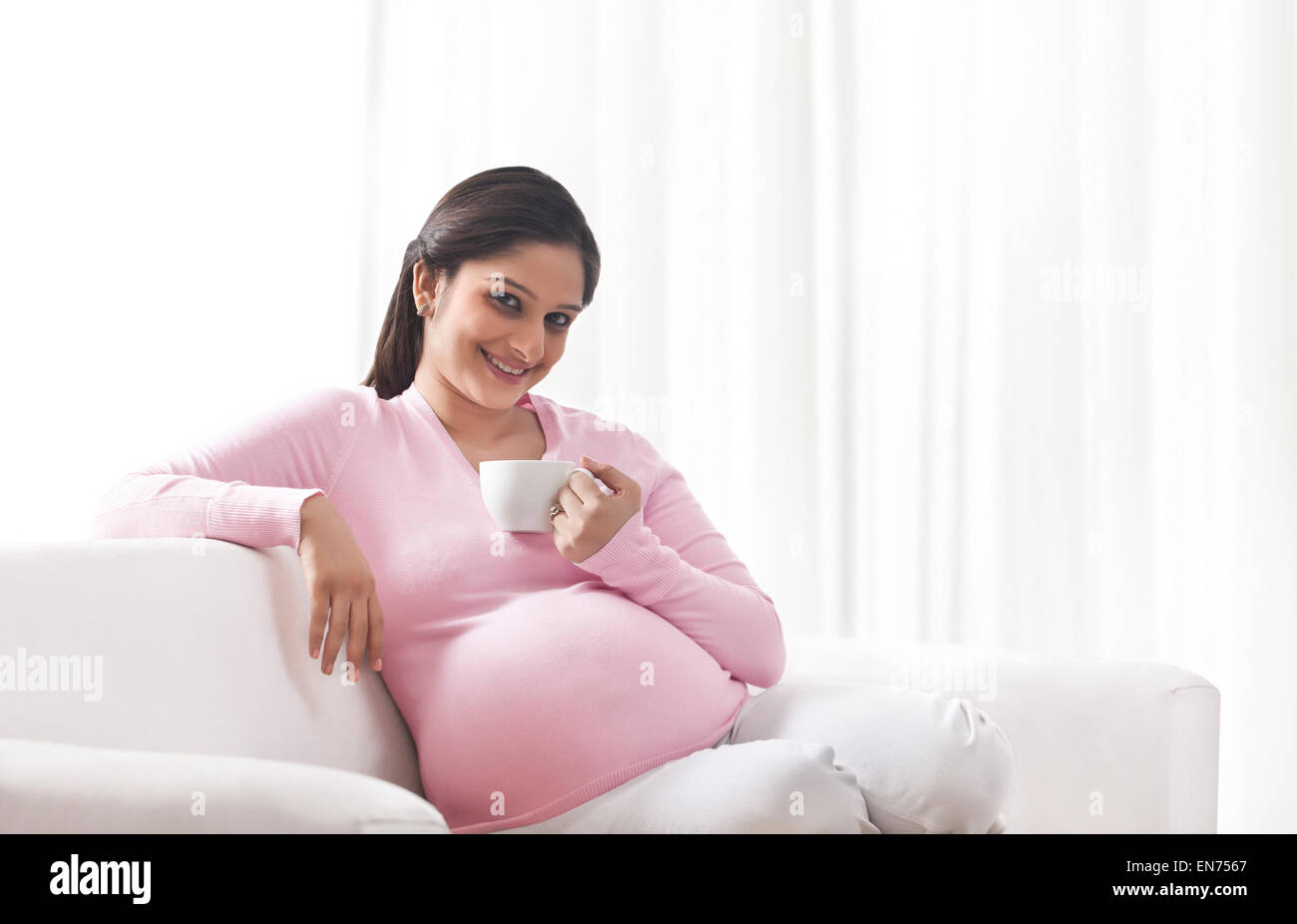 Portrait of a pregnant woman with a cup of coffee Stock Photo