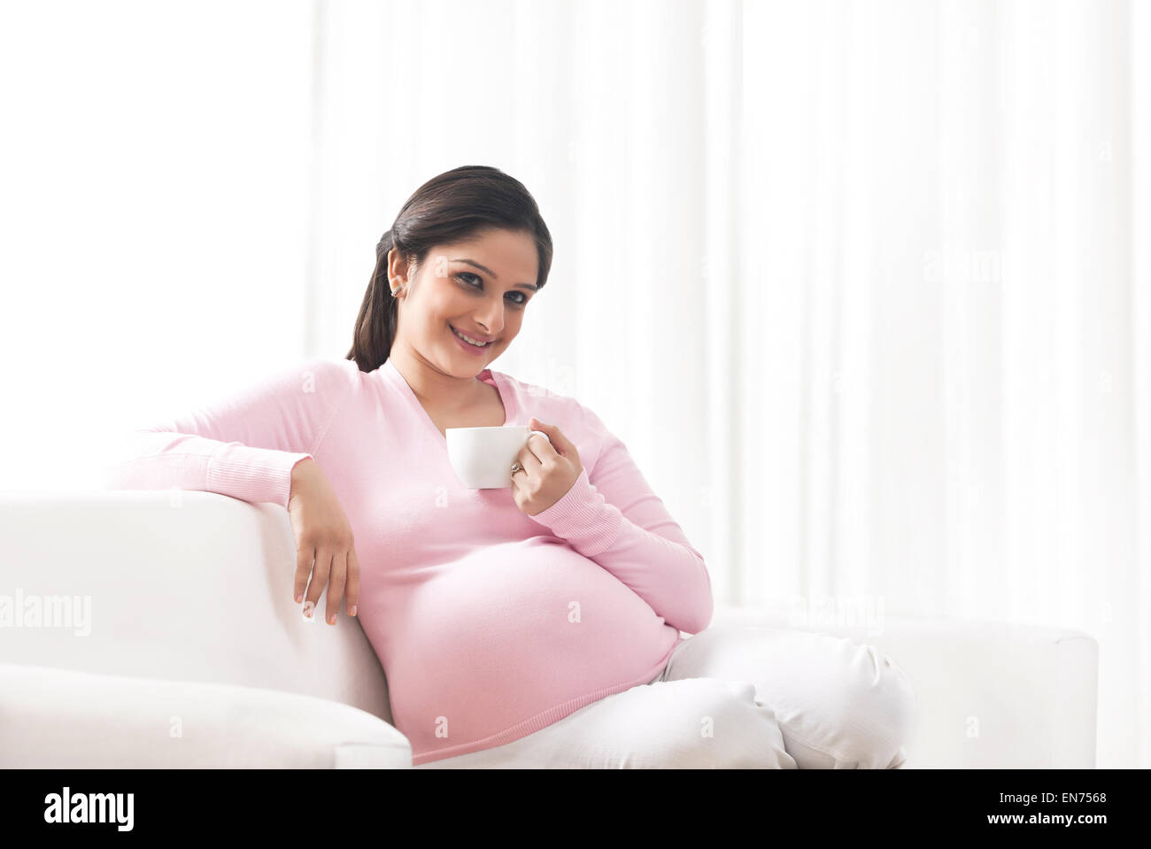 Pregnant woman with a cup of coffee Stock Photo