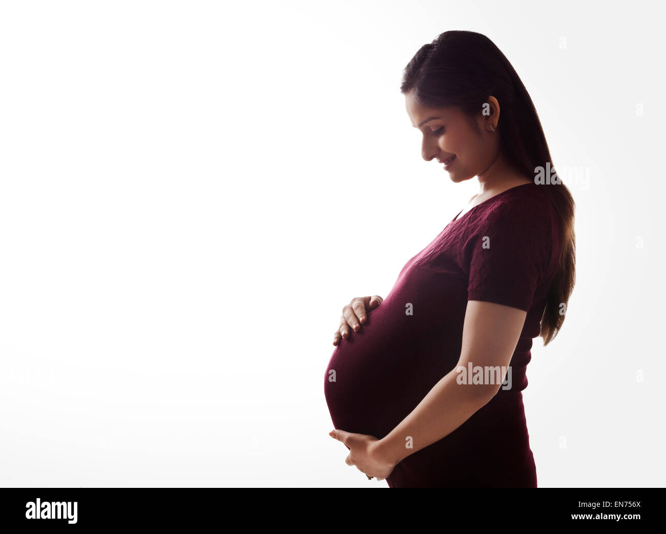 Pregnant woman holding her stomach Stock Photo - Alamy