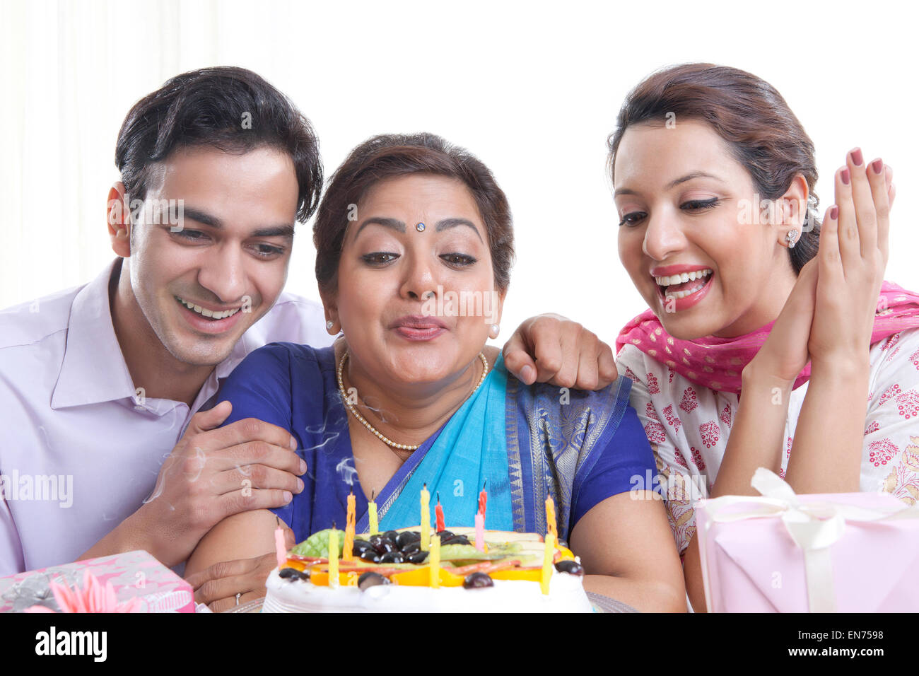 Woman blowing out candles on a birthday cake Stock Photo