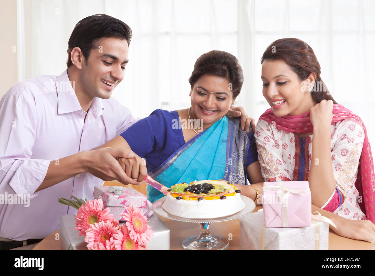 Woman cutting birthday cake with a knife Stock Photo