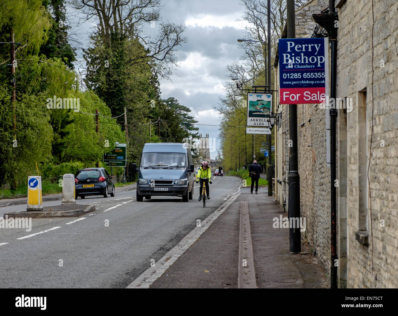 A van about to overtake a cyclist in high visibility jacket hi-vis hi vis on a British road Cirencester traffic safety concept Stock Photo