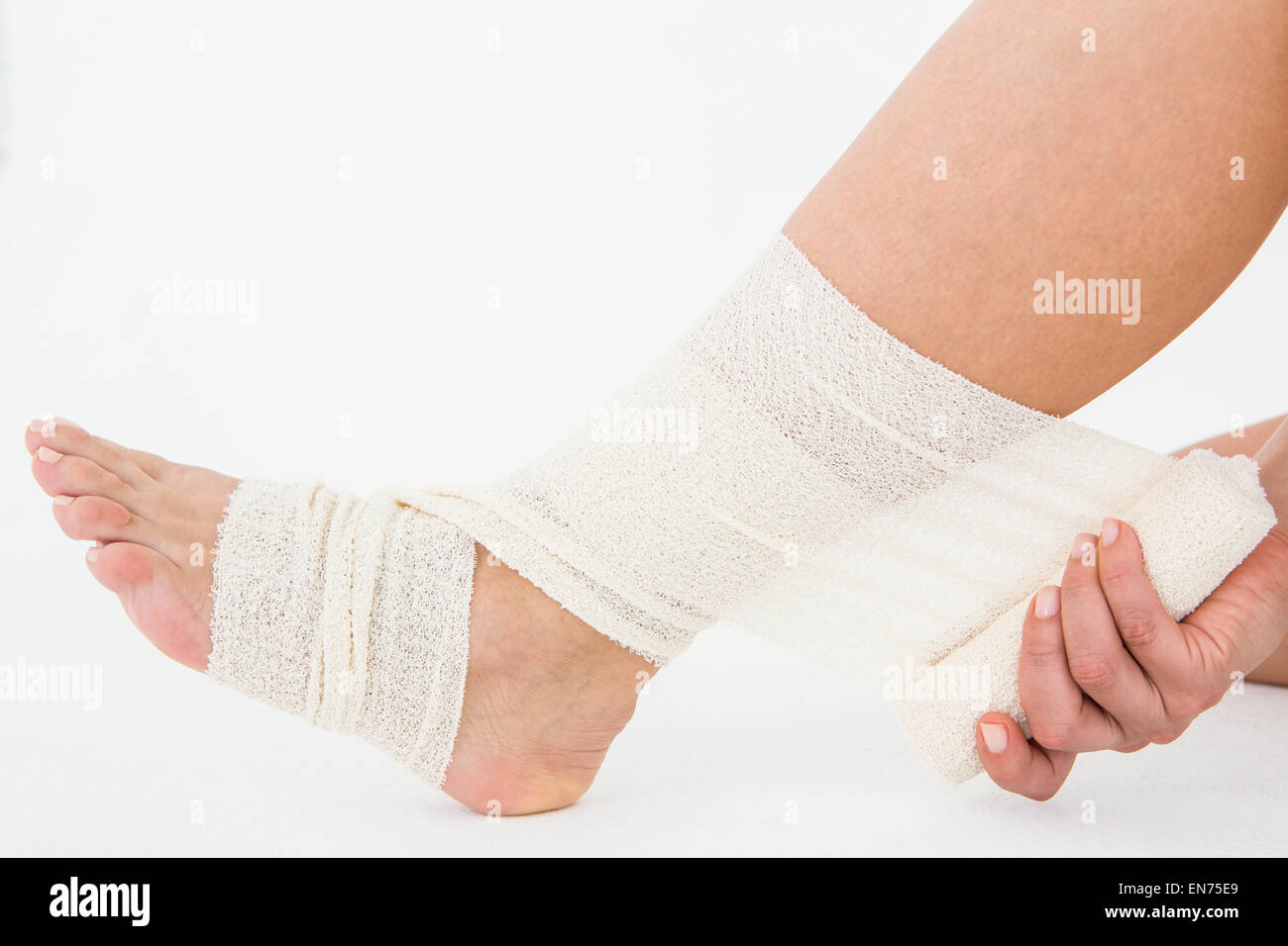 Sitting woman banding her ankle Stock Photo