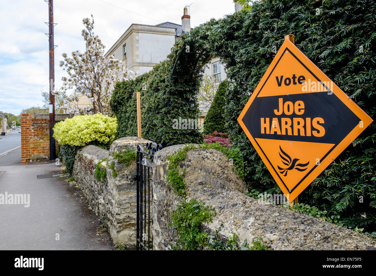A Liberal Democrat banner urging the public to vote for the local candidate in Cirencester, UK, on the garden wall of a house Stock Photo
