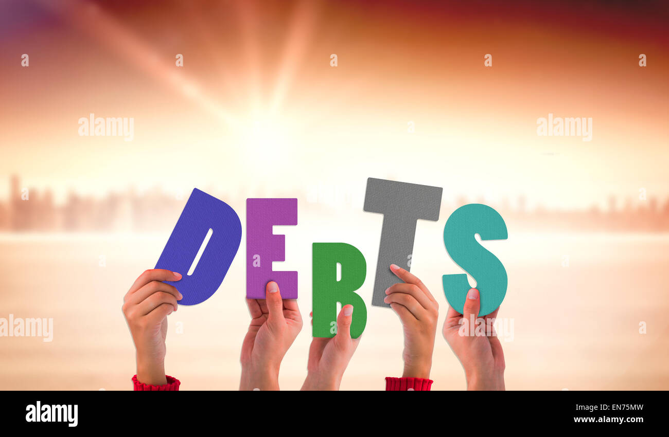 Composite image of hands holding up debts Stock Photo
