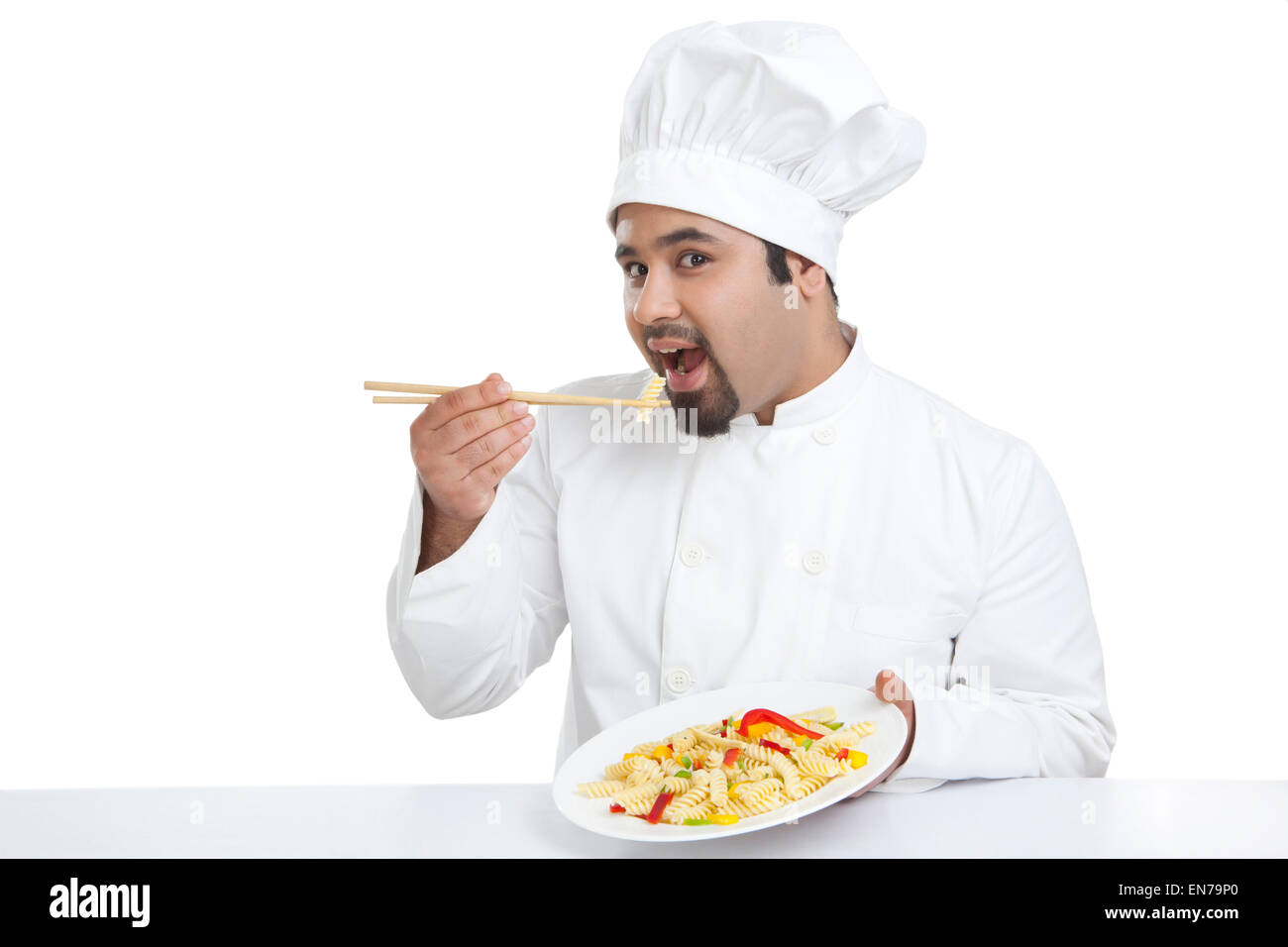Portrait of chef eating pasta with chopsticks Stock Photo