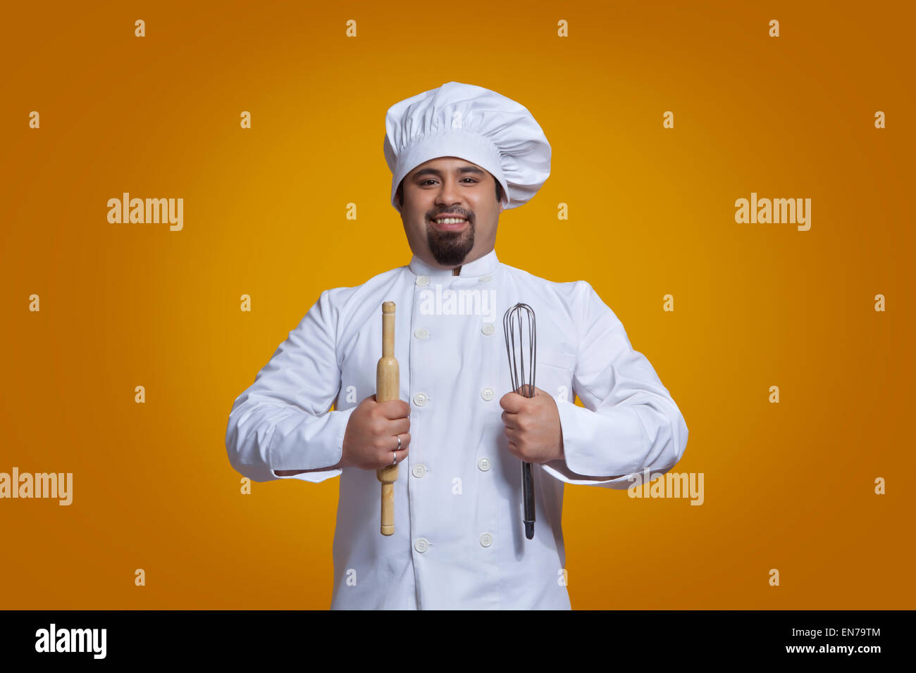 Portrait of chef holding wire whisk and rolling pin Stock Photo