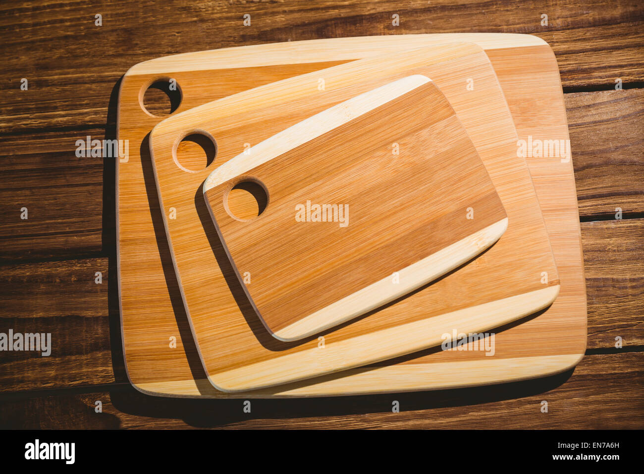 https://c8.alamy.com/comp/EN7A6H/chopping-boards-on-wooden-table-EN7A6H.jpg